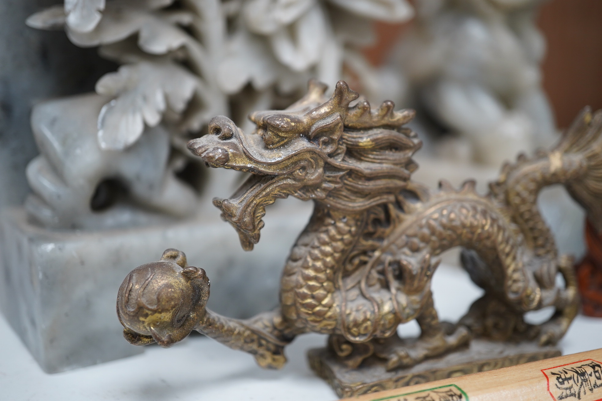 A group of Chinese items; a pair of turquoise glazed ceramic lion dogs, two pairs of soapstone carvings, various ‘dragon’ carvings etc. Condition - fair to good